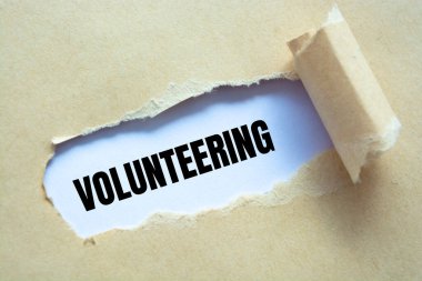 Kahverengi yırtık kağıdın altına yazılmış gönüllü kelime..