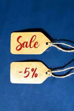 Satışlar% 5 indirimli fiyat etiketi ile kahverengi dizgi mavi arka planda