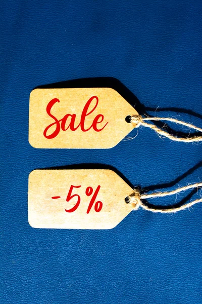 Sale Offer 5% off price tag with brown string on blue background
