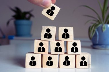 İnsan kaynakları, kurumsal hiyerarşi kavramı ve çok seviyeli pazarlama - bir lider (CEO) ve simge tarafından temsil edilen ahşap küp tarafından temsil edilen işe alım ekibi.