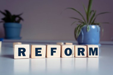 Metin, kelime reformu ahşap yapı taşlarına, hafif bir zemine yazılmış. İş konsepti