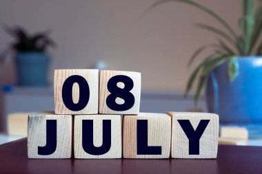 Farklı fikirlerde kullanmak için masa takvimi. Yaz ayı - Temmuz ve küplerin numarası 08. Katı bej bir arkaplanda tatil takvimi.