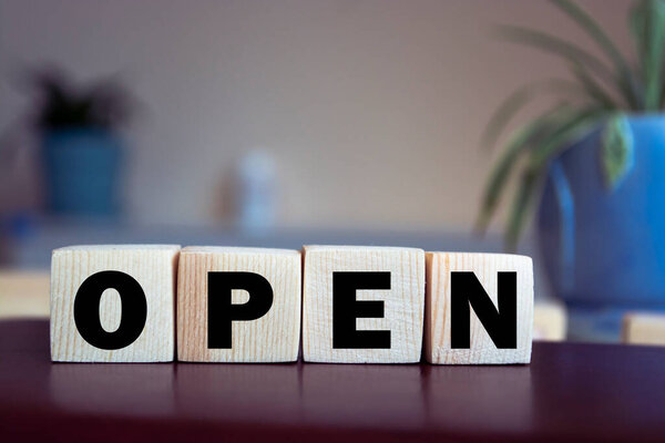 Word OPEN on wooden blocks or cubes. Opening business concept.