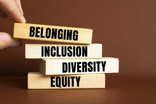 Equity, diversity, inclusion and belonging symbol. Wooden blocks with words \'equity, diversity, inclusion, belonging\' on brown background. Diversity, equity, inclusion and belonging concept.