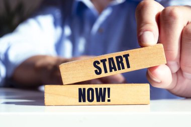 Erkek el ahşap blokta Başlangıç Şimdi metnini gösteriyor.