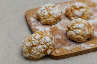 Masada keten masa örtüsü olan ev yapımı kurabiyeler.