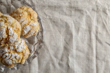 Masada keten masa örtüsü olan ev yapımı kurabiyeler.