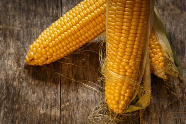 Kırsal ahşap masadaki koçandaki taze mısır. Yaklaş. Lezzetli ve sağlıklı yemekler..