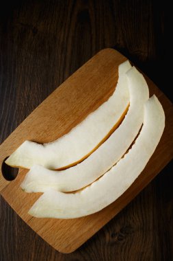 Dilimlenmiş kavun, ahşap masa zemininde bal kavunu. Çok sağlıklı, doğal, vejetaryen yiyecekler..