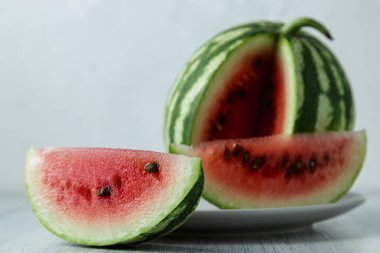 Tam ve dilimlenmiş karpuz, ahşap masa arkasında ballı karpuz. Çok sağlıklı, doğal, vejetaryen yiyecekler..