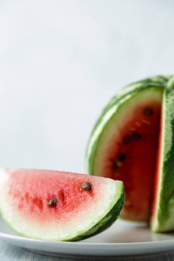 Tam ve dilimlenmiş karpuz, ahşap masa arkasında ballı karpuz. Çok sağlıklı, doğal, vejetaryen yiyecekler..