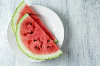 Dilimlenmiş karpuz, ahşap masa arkasında ballı karpuz. Çok sağlıklı, doğal, vejetaryen yiyecekler..