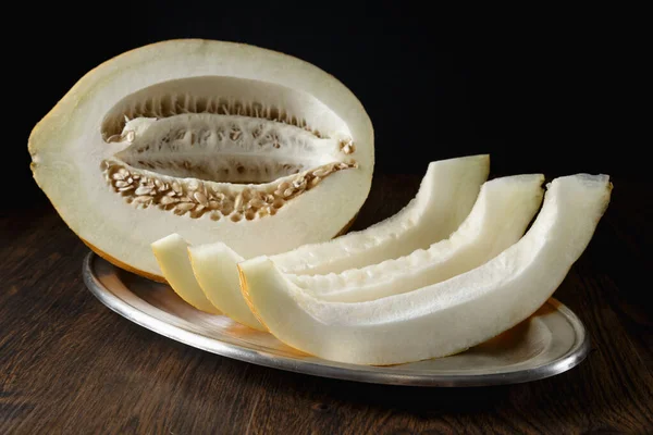 Tam ve dilimlenmiş kavun, ahşap masa zemininde ballı kavun. Çok sağlıklı, doğal, vejetaryen yiyecekler..