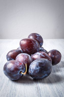 Ahşap bir masada mavi erik. Mesaj için yer. Fotokopi alanı olan meyve arkaplanı. Durgun yaşam yemeği.