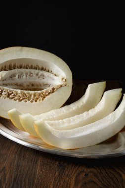 Tam ve dilimlenmiş kavun, ahşap masa zemininde ballı kavun. Çok sağlıklı, doğal, vejetaryen yiyecekler..