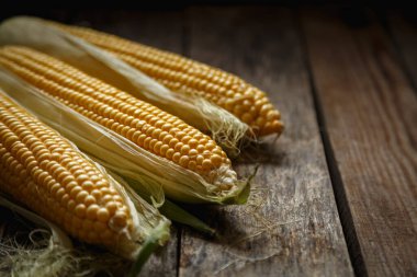 Kırsal ahşap masadaki koçandaki taze mısır. Yaklaş. Lezzetli ve sağlıklı yemekler..