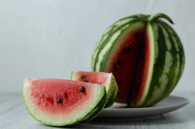 Tam ve dilimlenmiş karpuz, ahşap masa arkasında ballı karpuz. Çok sağlıklı, doğal, vejetaryen yiyecekler..