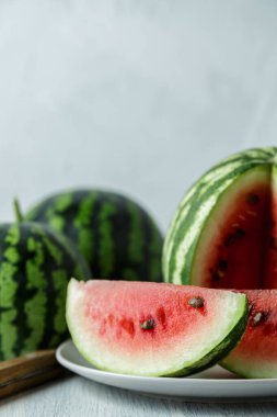 Tam ve dilimlenmiş karpuz, ahşap masa arkasında ballı karpuz. Çok sağlıklı, doğal, vejetaryen yiyecekler..