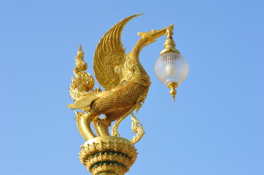 Mavi gökyüzü üzerinde altın kuğu heykeli