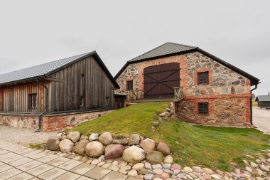 Geleneksel Letonya kırsal mimarisinin karışımını vurgulayarak, yenilenmiş taş ve tuğla ahşap ek binalarla yan yana sergilenen tarihi Nurme Malikanesi 'nin dış görünüşü