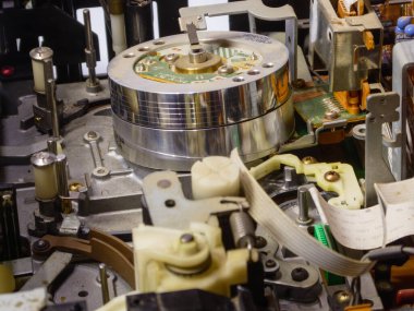 Manyetik başlıkları gösteren parçalanmış bir VCR oynatıcısının ayrıntılı kapatılması.