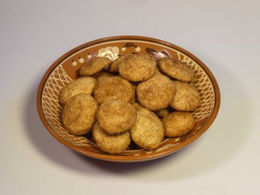 Geleneksel dekore edilmiş kil tabakta servis edilen lezzetli taze tarçınlı kurabiyeler..