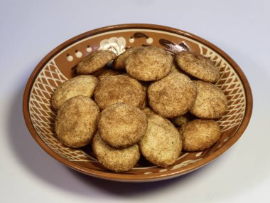 Geleneksel bir klozette servis edilen taze pişmiş tarçın şekerli kurabiyeler.