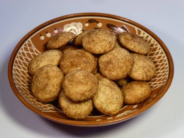 Geleneksel seramik kasede servis edilen taze pişmiş tarçınlı kurabiyeler.