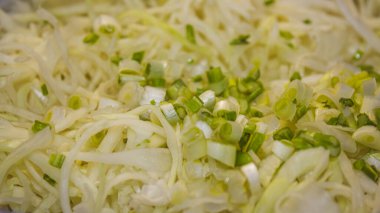 Dilimlenmiş lahana ve taze soğanlı sağlıklı çiğ sebze salatası..