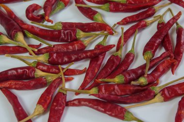 Beyaz arka planda bir sürü kurutulmuş kırmızı biber. Baharatlı sıcak baharata yakın çekim. Organik baharat ve sağlıklı yemek pişirme kavramı..