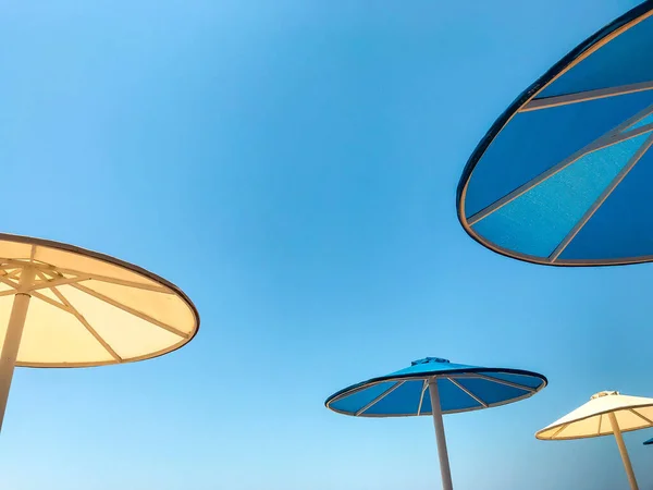 Gele Blauwe Strandparasols Achtergrond Van Blauwe Lucht Zonnestralen Zomervakantie Aan — Stockfoto