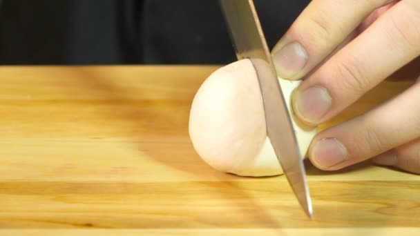 Gesneden champignons voor koken slowmotion op houten tafel — Stockvideo