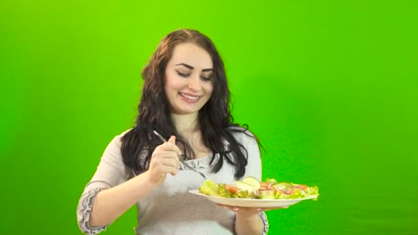 Girl eats on a green background 4K — Stock Video