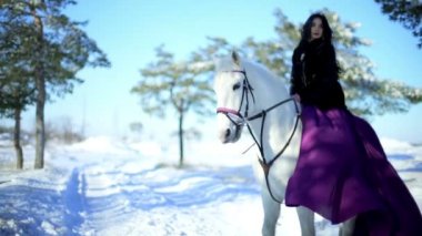 Genç erkek açık beyaz atın üzerinde oturanbir