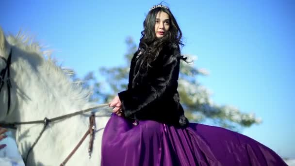 Junge Frau sitzt auf dem weißen Pferd im Freien — Stockvideo