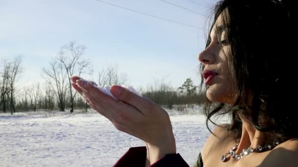 Closeup of teen girl blowing a handful of snow in slow motion — Stock Video