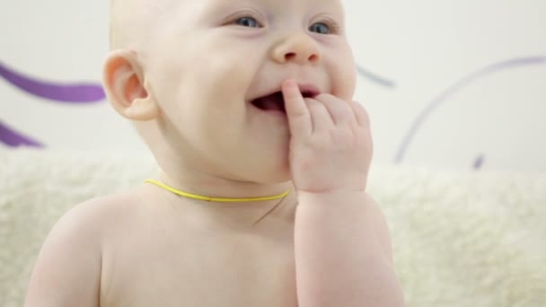 Baby flicka kryper på soffan och leker med leksaker — Stockvideo