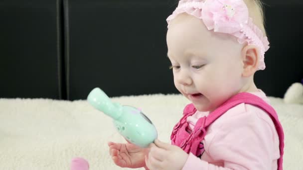 Niña sentada en el sofá jugando juguetes, concepto de educación temprana para niños pequeños . — Vídeos de Stock