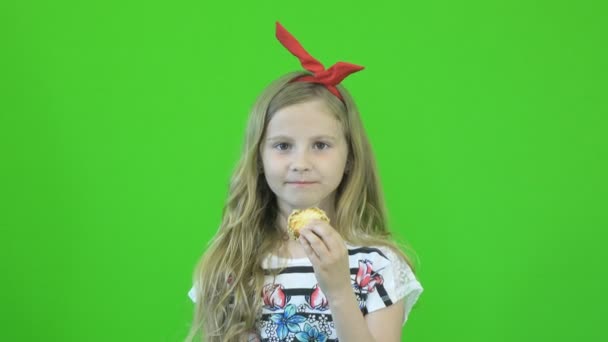 Meisje eten cookies op chromakey — Stockvideo