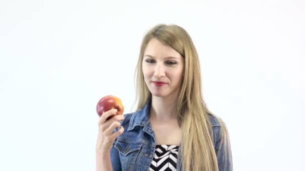 Beautiful girl eats a red apple on a white background UHD 4K — Stock Video