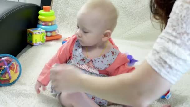 彼女の小さな女の赤ちゃんのドレスを入れてママ — ストック動画