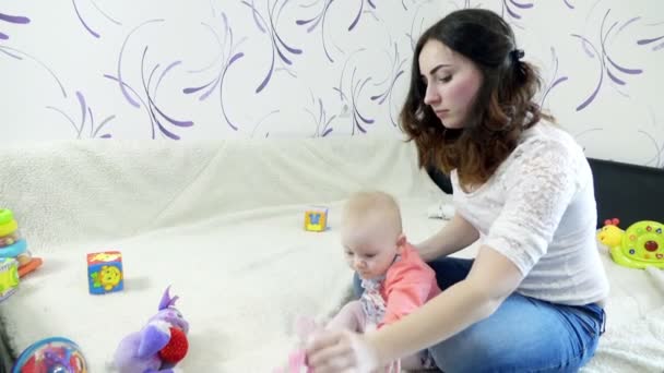 Mamá poniendo vestido en su pequeña niña — Vídeo de stock