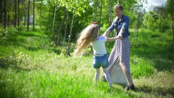 Junge Mutter mit ihrer Tochter beim Spielen im Frühlingspark — Stockvideo