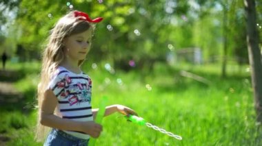 Sabun köpüğü bahar parkta üfleyen mutlu çocuk