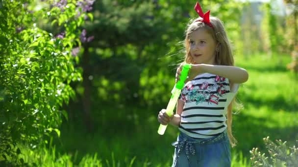 Gelukkig kind blazen van zeepbellen in voorjaar park — Stockvideo