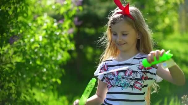 Niño feliz soplando burbujas de jabón en el parque de primavera — Vídeos de Stock