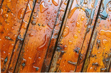 Su damlaları olan ahşap tahtalar, neme karşı koruyucu yağ ile kaplı.