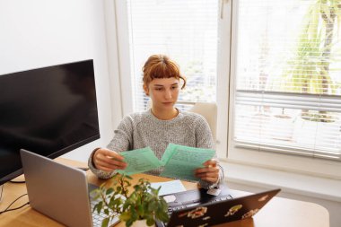 Laptop kullanan genç bir kadın, not defteri, ev içi öğrenim, iş