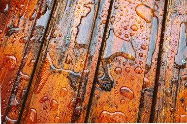 Su damlaları olan ahşap tahtalar, neme karşı koruyucu yağ ile kaplı.