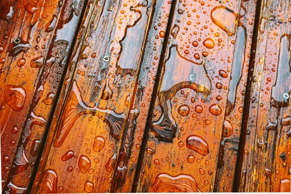 Su damlaları olan ahşap tahtalar, neme karşı koruyucu yağ ile kaplı.